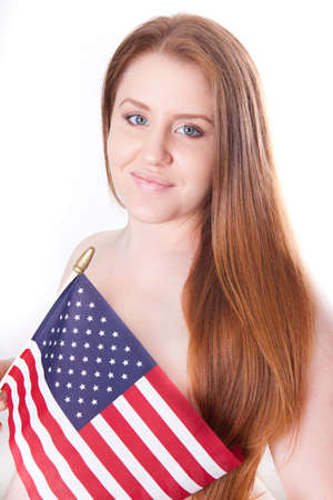 Beautiful pregnant woman holding American flag with long red hairの写真素材