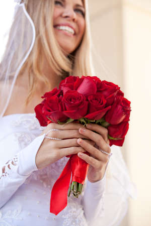 A Bride holding a Beautiful Red Rose Bouquetの写真素材