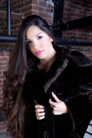 Beautiful Young Woman with long hair wearing a Faux fur coatの写真素材