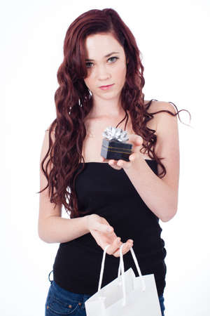Pretty young brunette with long Hair holding a small gift box and bagの写真素材
