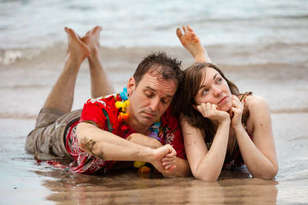 Tourist Couple on the Beach in Hawaii with a contemplative lookの写真素材