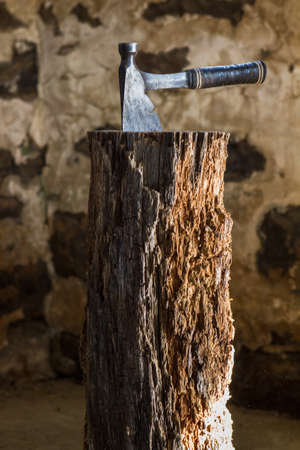 Vintage Axe on a chopping block log in an old barnの写真素材