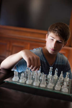Male Teenager thinking of his strategy in chessの写真素材