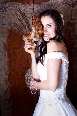 Beautiful Bride Masquerading with a feathered maskの写真素材