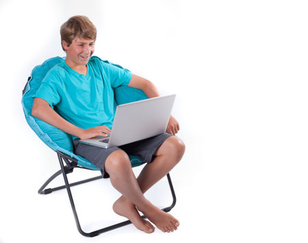 Happy Teen on Laptop Computer sitting in a chair