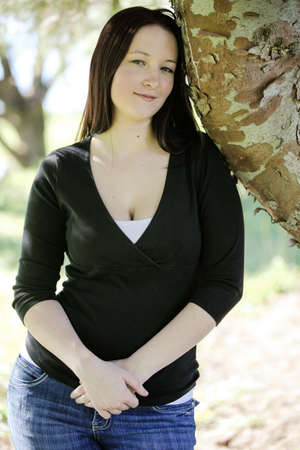 Young woman by a tree hands crossed looking peacefulの写真素材