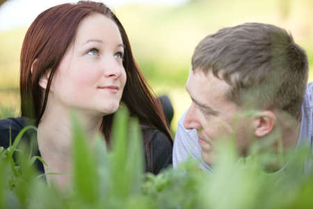 Man and woman  on the ground in tall grass dreaming togetherの写真素材