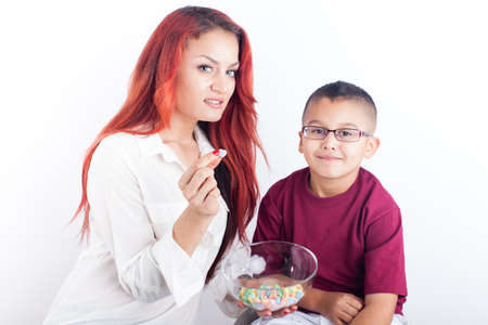Valentine's day Pretty young mom and her son with a bowl of heart shaped candiesの写真素材