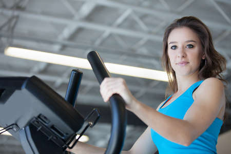 Attractive young woman in Blue at the Gym on stair steppersの写真素材
