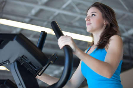 Attractive young woman in Blue at the Gym on stair steppersの写真素材