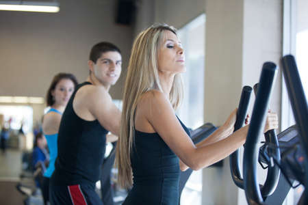 Attractive young woman in Black at the Gym on stair steppersの写真素材