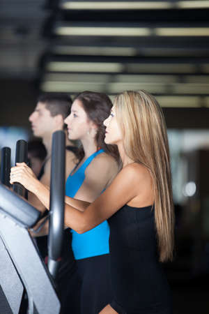 Attractive young group of friends at the Gym on stair steppers talkingの写真素材