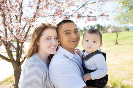 Cherry Blossoms surround a Beautiful young family in Spring timeの写真素材