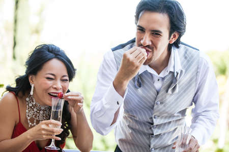 Formal occasion friends eating Strawberries and drinking champagneの写真素材