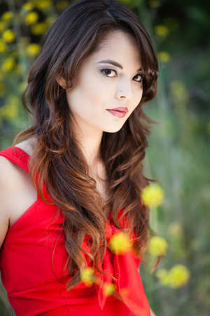 Beautiful Woman in a Red  Dress and yellow flowersの写真素材