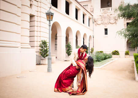 Gorgeous Indian bride and groom in a dramatic pose in front of the churchの写真素材
