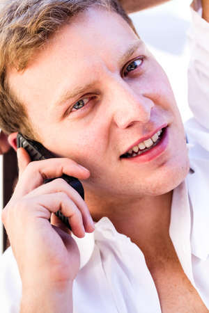 Close up blonde Attractive Man in his twenties on a Cell phoneの写真素材