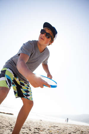 Attractive Teenager tossing a disc at the beach in Malibu Californiaの写真素材
