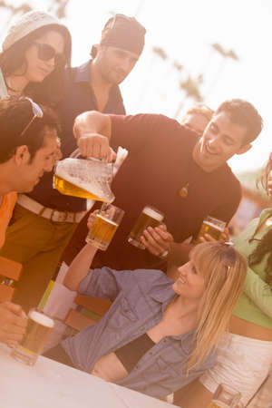 Attractive Man pouring a beer at an outside cafe on the Beach in Venice Californiaの写真素材