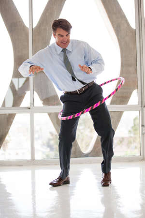 Business Man loosning up with a Hoop for his meetingの写真素材
