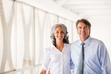 Good looking Business man and woman walking smiling at cameraの写真素材