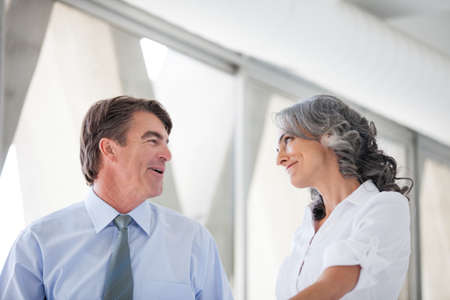 Good looking Business man and woman walking smiling at each otherの写真素材