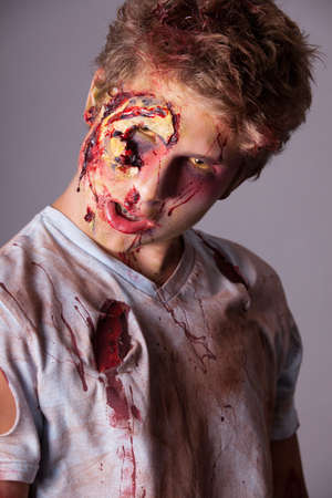 Sneering Teenager Zombie in torn bloody shirtの写真素材