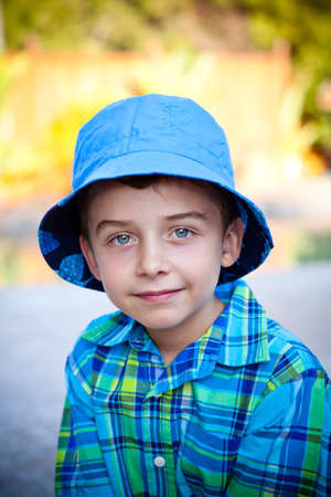 Portrait of a cute boy in a blue hat during summerの写真素材