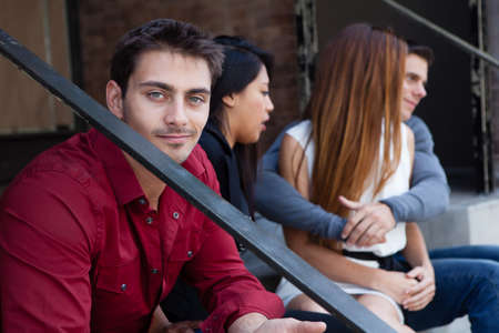 Attractive man with his friends smiling at camera sitting together on vacation in Los Angeles , Californiaの写真素材