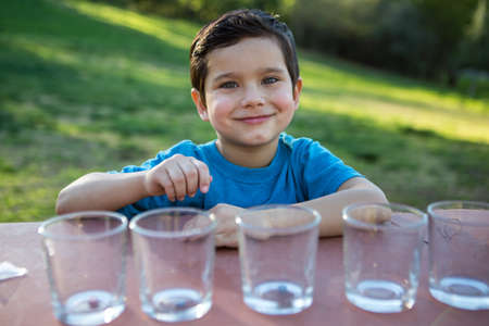 Chid sitting with glasses ready to color eggsの写真素材