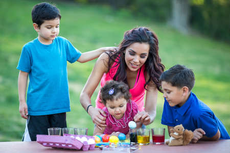 Family having fun coloring Easter eggsの写真素材