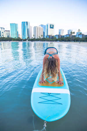 SUP Yoga practice early morning in Waikikiの写真素材