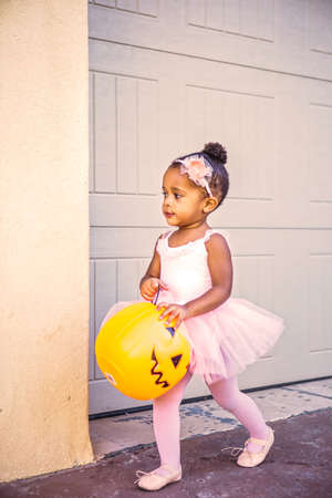 Cute 2 year old girl trick or treating in her ballet outfitの写真素材