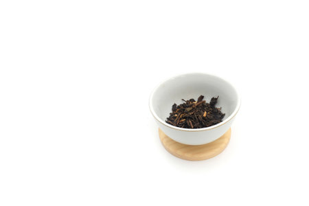 Dry black tea in round bowl isolated on white backgroundの写真素材