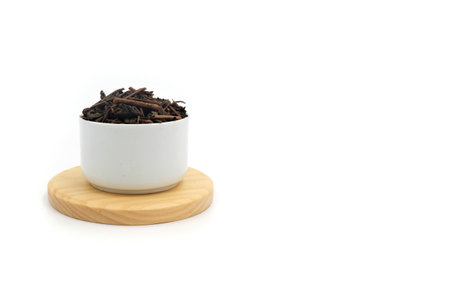 Dry black tea in round bowl isolated on white backgroundの写真素材
