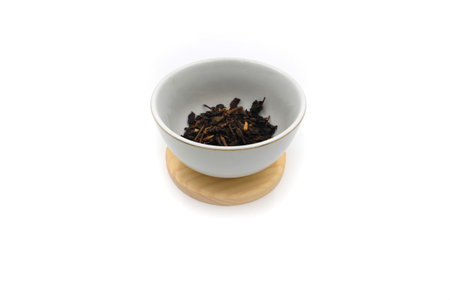 Dry black tea in round bowl isolated on white backgroundの写真素材