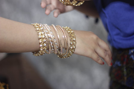 close up of gold bracelet on bride's handの写真素材