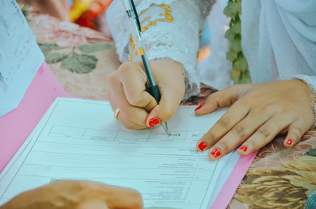 closeup of the bride's hands signing the marriage certificateの写真素材