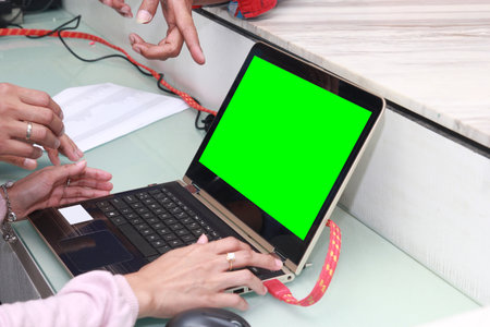 asian young woman working with laptop, using finger with keyboard for typing. computer laptop with blank green screen chroma key. Close up viewの写真素材