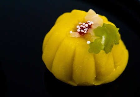 A single Japanese sweet (wagashi) shot close-up on a black lacquer plate