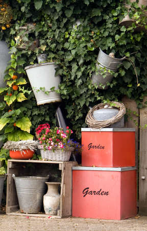 A lovely garden wall displaying garden equipment, plantings, and decorative boxesの写真素材