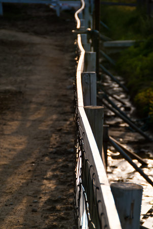 A highlighted railing fence cuts across the frameの写真素材