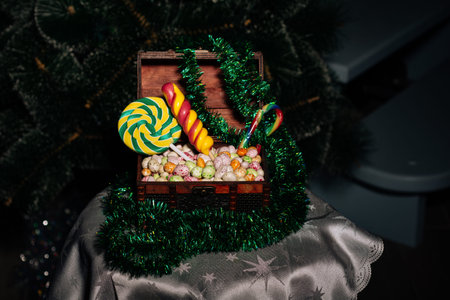 Wood Box with assorted delicious candy and tinsel for New Year and Christmas. New Year's sweets on a...