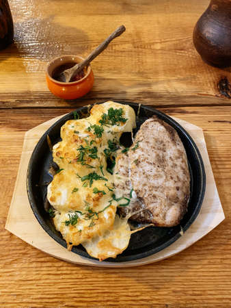 hot baked chicken with potatoes and cheese in a rustic styleの写真素材