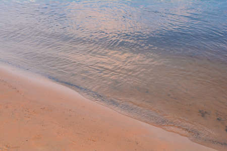 river surface and sand beach. water surface. water background. blue and sunny water surface. abstract blue waterの写真素材
