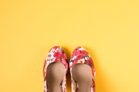 Bright colored pink women's shoes with medium heels on a yellow background. Top View. Flat Lay. Copy...