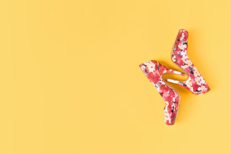 Bright colored pink women's shoes with medium heels on a yellow background. Top View. Flat Lay. Copy...