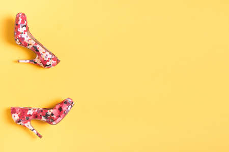 Bright colored pink women's shoes with medium heels on a yellow background. Top View. Flat Lay. Copy Space. Shoes sale, ad design conceptの写真素材