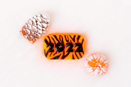 Top view Christmas and New Year decorations, pine cone, mandarin, 2022 on a light background. Flat...
