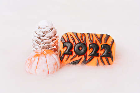 Christmas and New Year decorations, pine cone, mandarin, 2022 on a light background. Handmade New Year soap. Xmas toys. Holiday concept, gifts and homemade soapの写真素材